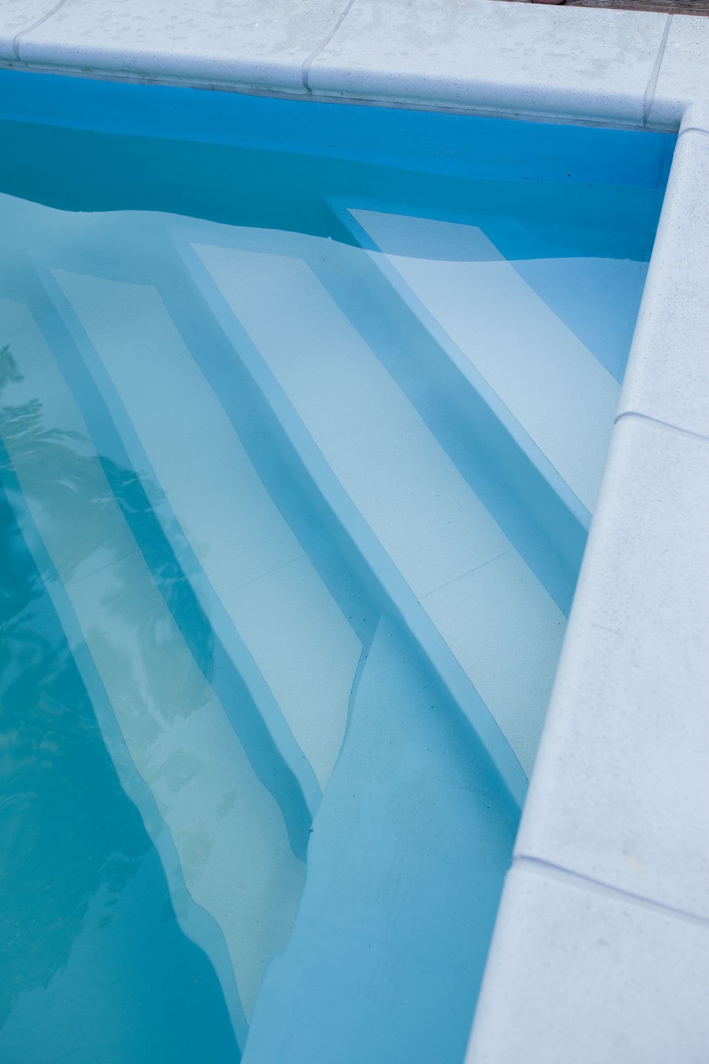 Crystal-clear residential pool with clean tiled steps, freshly serviced and swim-ready